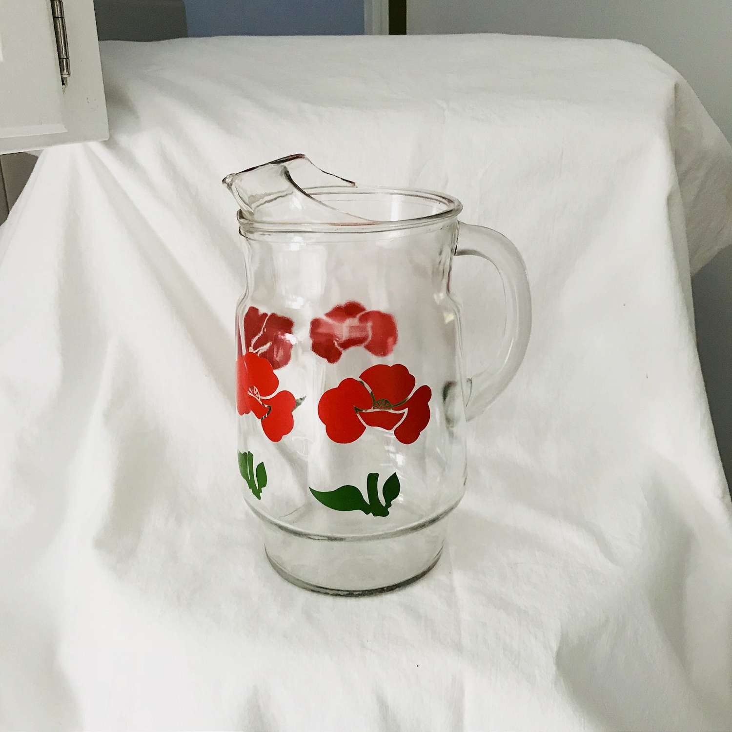 https://www.truevintageantiques.com/wp-content/uploads/2019/12/vintage-pitcher-glass-fired-on-paint-red-flowers-iced-tea-koolaid-collectible-retro-kitchen-display-farmhouse-summer-picnic-patio-water-5df953b67-scaled.jpg