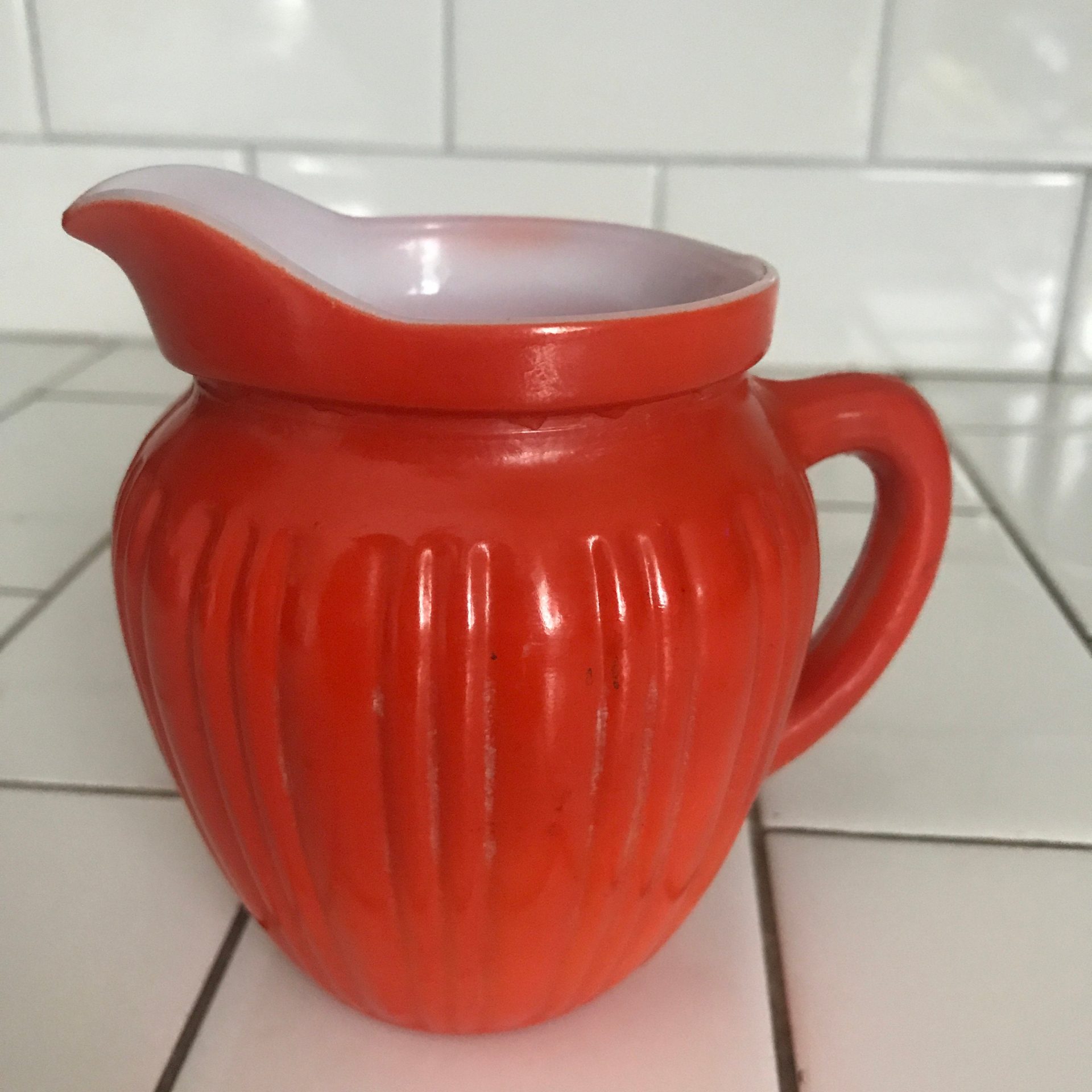 https://www.truevintageantiques.com/wp-content/uploads/2021/05/vintage-cream-pitcher-orange-fired-on-paint-white-milk-glass-ribbed-farmhouse-cottage-collectible-kitchen-decor-609926703-scaled.jpg